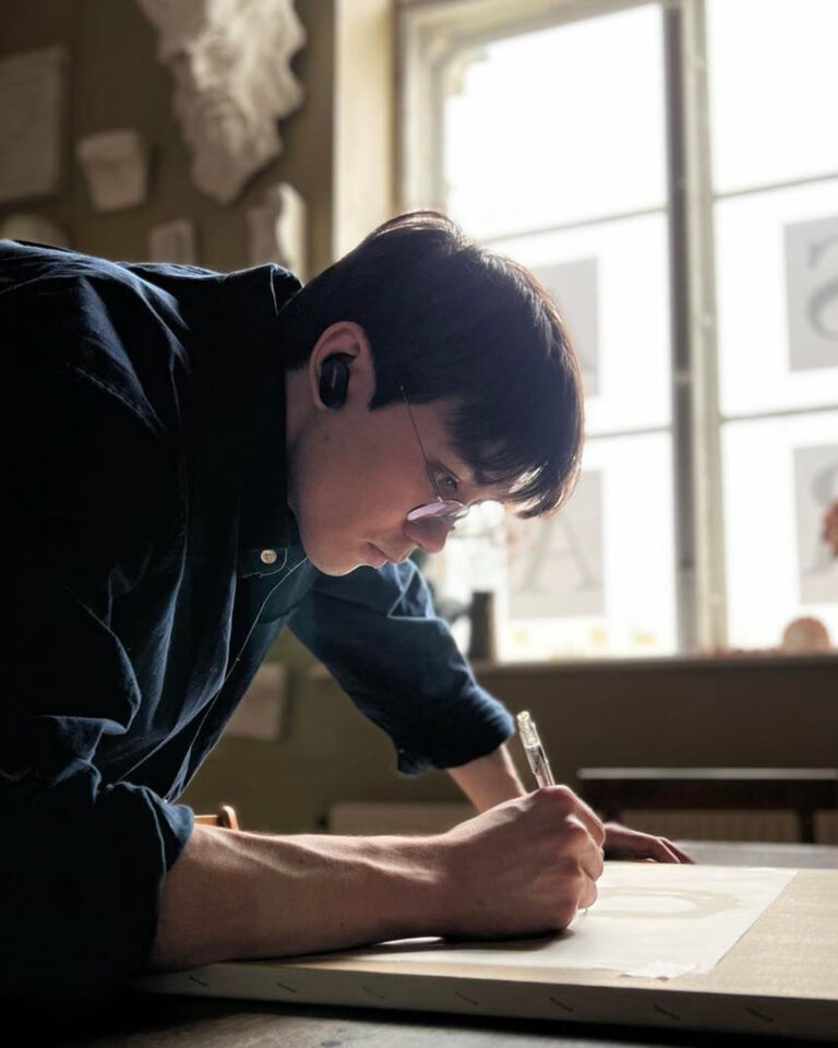 Naoki Azuma drawing on a paper
