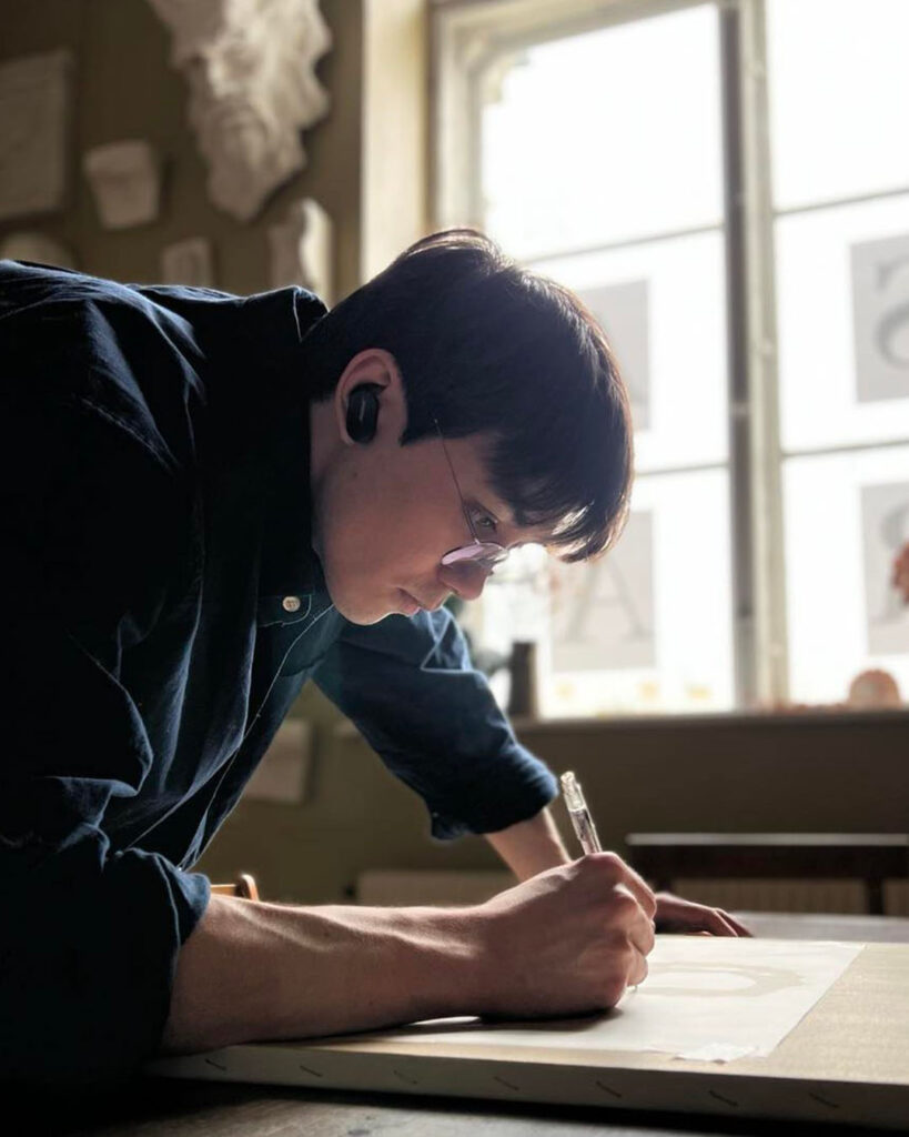 Naoki Azuma drawing on a paper