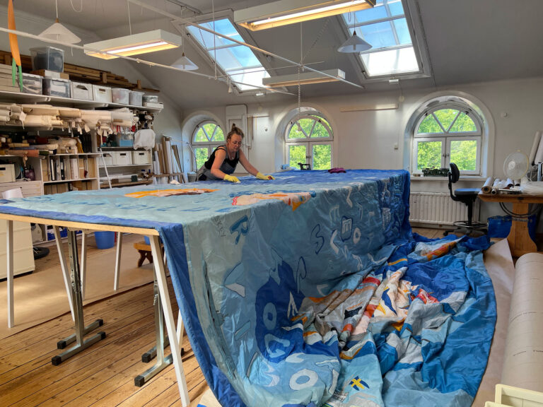 Anna Eriksson renoverar Gösta Werners ridå till Berga Örlogsbas, Foto Handarbetets Vänner